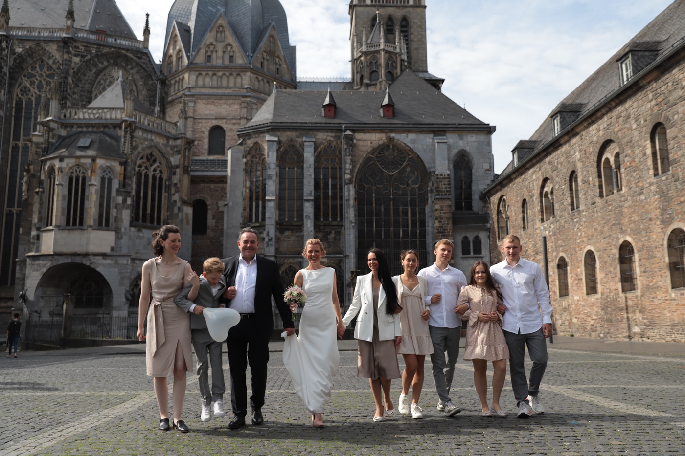 Hochzeitsgesellschaft vor einer historischen Kirche