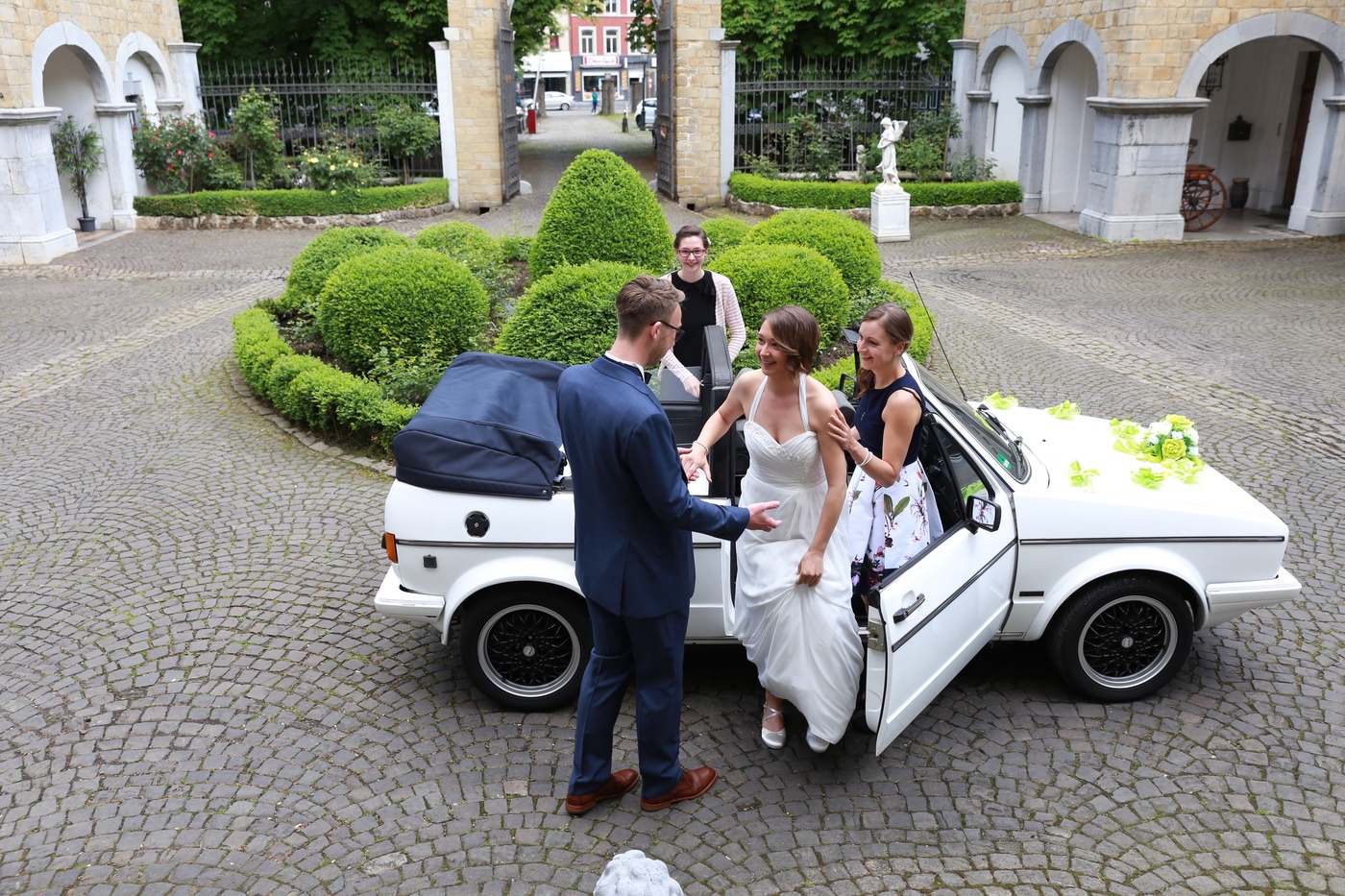Brautpaar steigt aus dem geschmückten Oldtimer