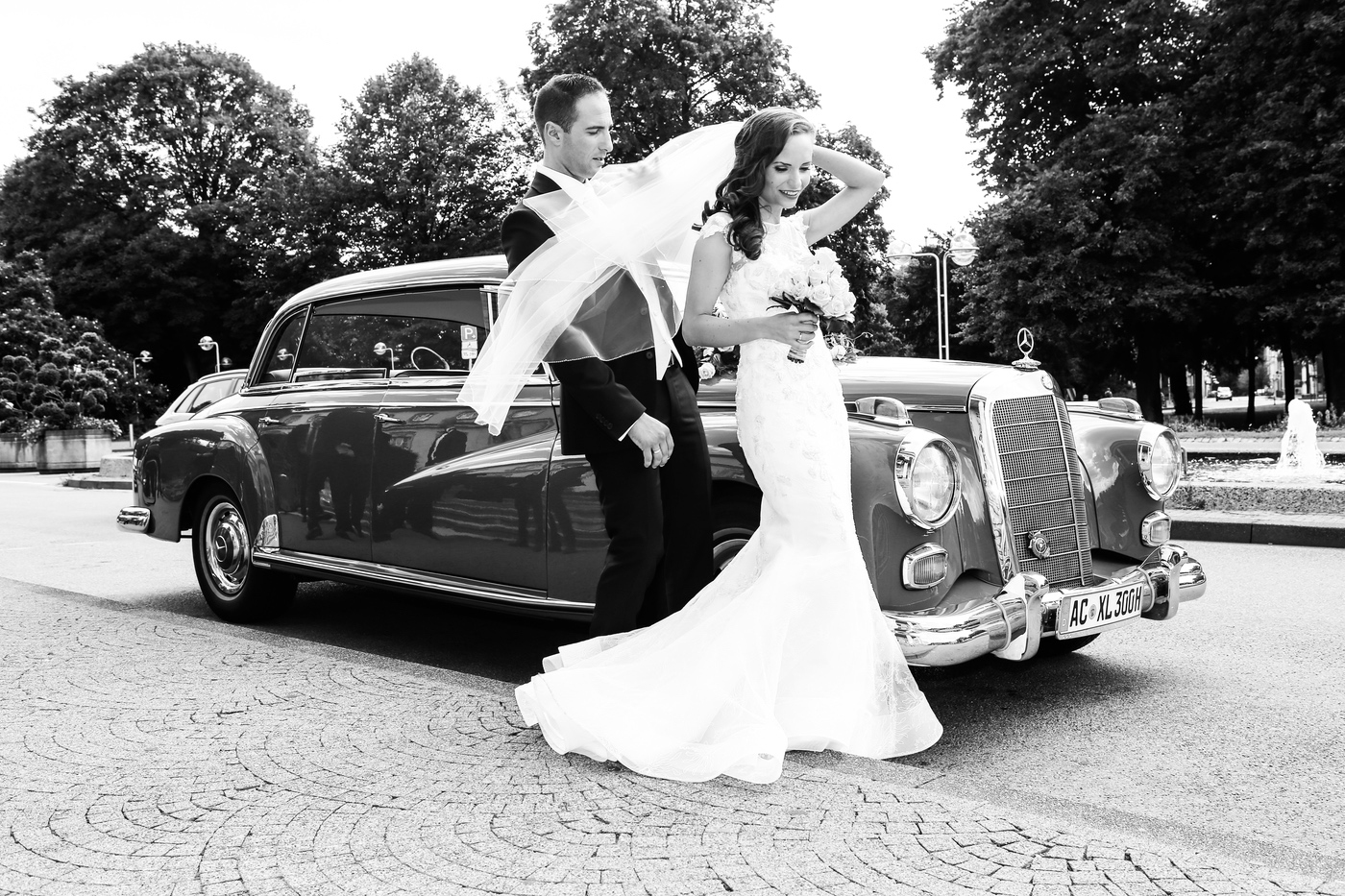 Braut vor dem Hochzeitsauto, schwarzweiß