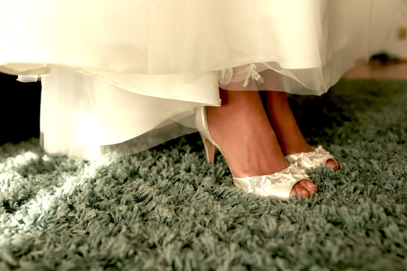 Brautschuhe unter dem Saum des Hochzeitskleids