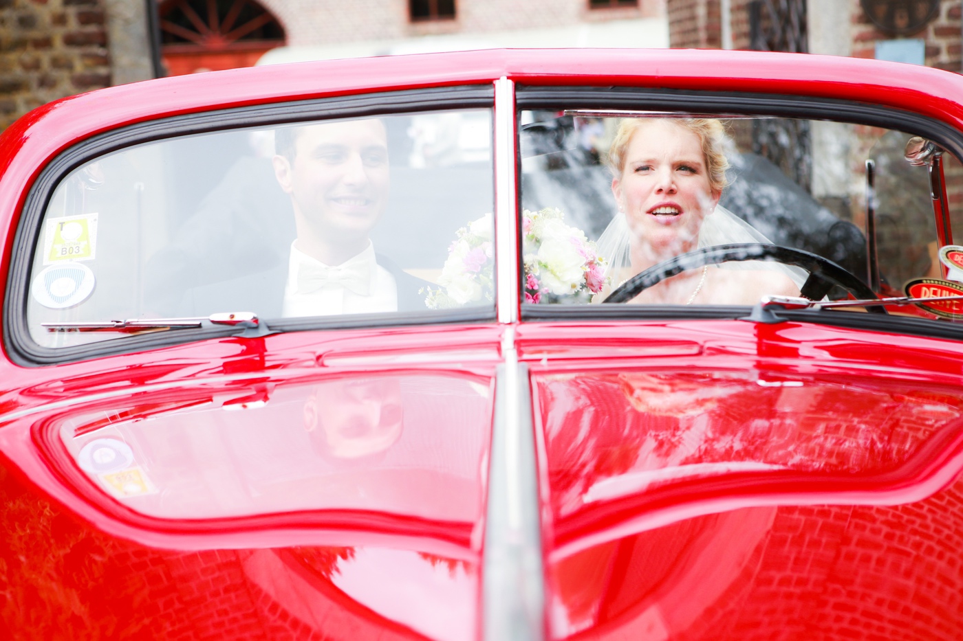 Brautpaar im roten Oldtimer